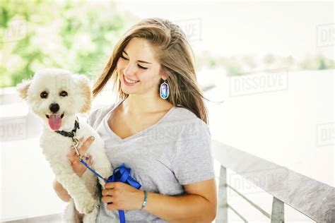 woman carrying dog